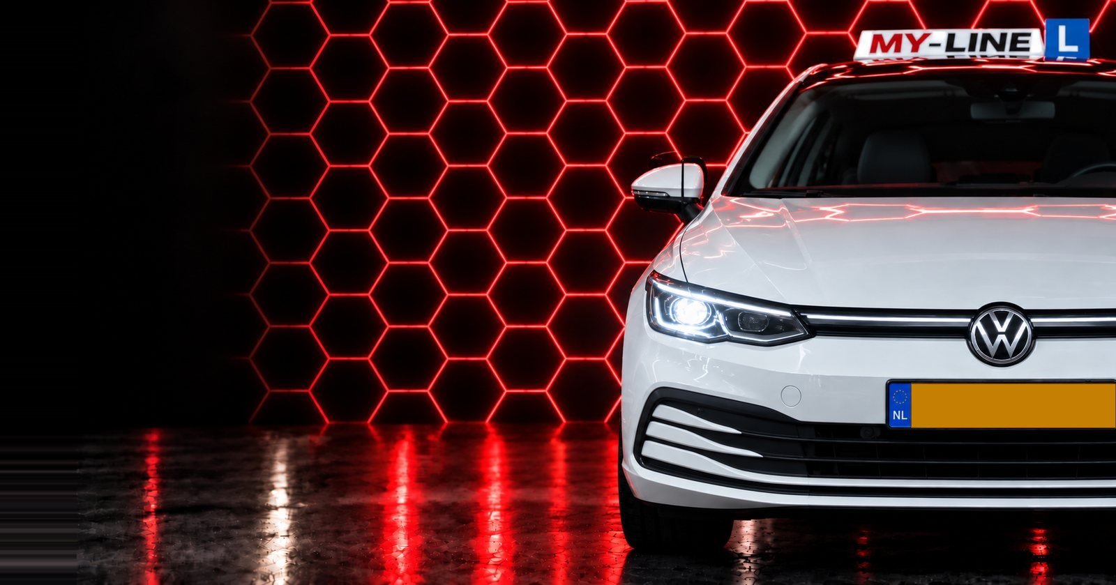 De witte Volkswagen Golf van Rijschool MY-Line met het dakbord voor een wand van rode lichtende zeshoeken
