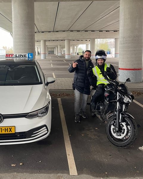 De instructeur van MY-Line met een motorleerling op de lesmotor, naast de witte lesauto