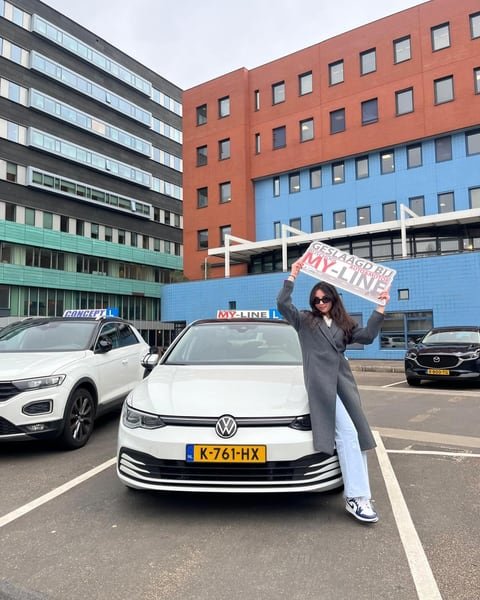 Geslaagde leerling van MY-Line bij de lesauto of de lesmotor