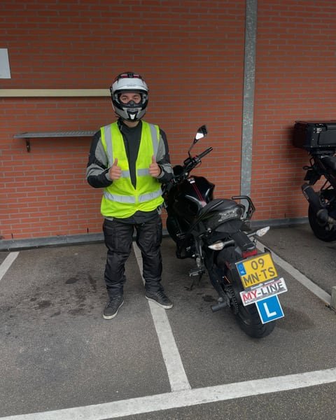 Motorleerling met helm en geel hesje naast de lesmotor van MY-Line