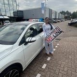 Geslaagde leerling met het bord van MY-Line bij de lesauto of lesmotor