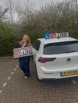 Geslaagde leerling met het bord van MY-Line bij de lesauto of lesmotor