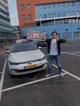 Geslaagde leerling met het bord van MY-Line bij de lesauto of lesmotor
