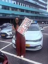 Geslaagde leerling met het bord van MY-Line bij de lesauto of lesmotor