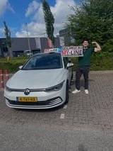 Geslaagde leerling met het bord van MY-Line bij de lesauto of lesmotor