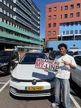 Geslaagde leerling met het bord van MY-Line bij de lesauto of lesmotor